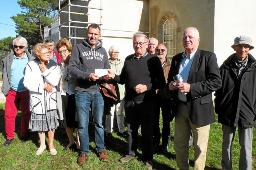 Stéphane Gilbert offre un chèque de 500 € à Claude Le Brun, président des Amis de la chapelle de Penmern, en présence de l'adjoint René Goallo, devant la chapelle en plein travaux.